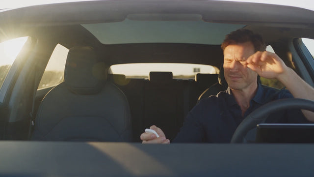 A driver shielding his eyes from low sun, then relaxed at the wheel, and the car driving with its side windows switched